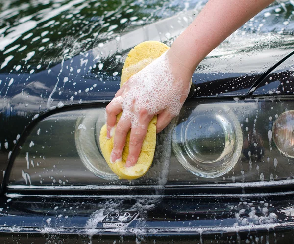 Γυναικείο χέρι με κίτρινο σφουγγάρι πλύσιμο αυτοκινήτου — Φωτογραφία Αρχείου