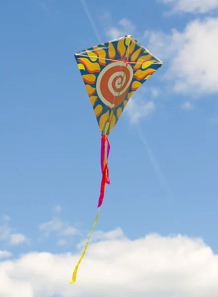 Colorful kite soaring against a blue sky. — Stock Photo, Image