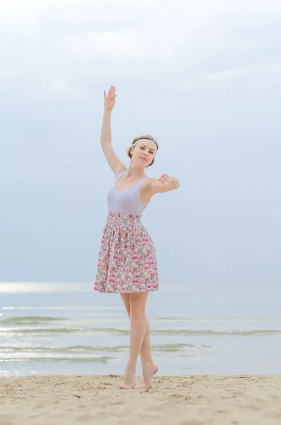 Young woman doing dancing elements near the sea — Stock Photo, Image