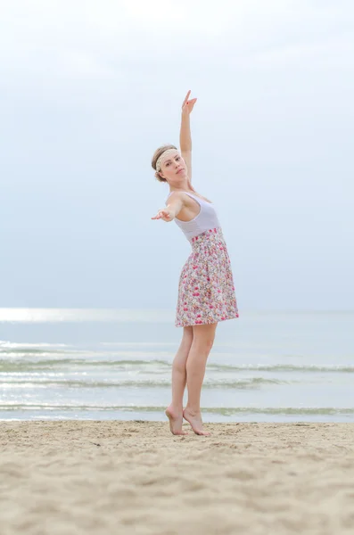 Ung kvinna gör dansande element nära havet — Stockfoto
