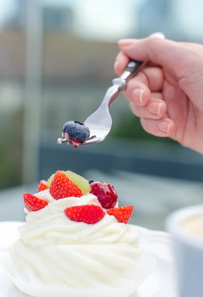 Gâteau crémeux blanc aux fraises et fourchette à main féminine — Photo