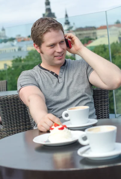 Young man have a rest with cup of coffee in outdoor cafe — Stock Photo, Image