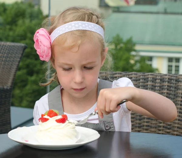Petite fille mignonne mangeant du gâteau dans un café extérieur — Photo