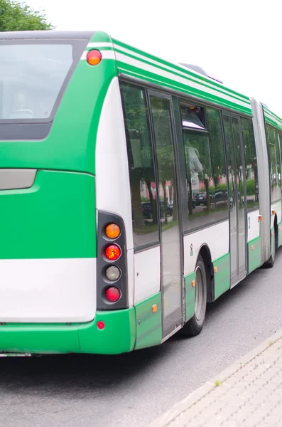 Nowoczesne zielony autobus miejski odjeżdża z przystanku — Zdjęcie stockowe