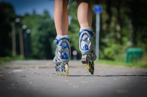 Vista ravvicinata delle gambe femminili nelle pale dei rulli — Foto Stock