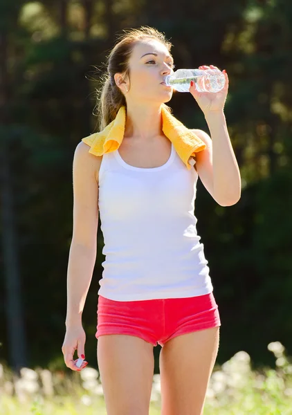 スポーティな若い女性水を飲む運動をした後 — ストック写真