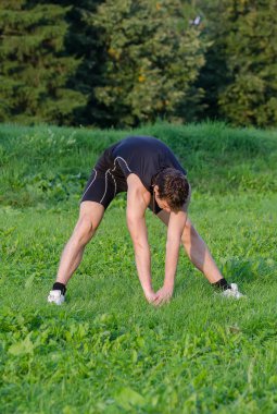 Genç sporcunun Park'ta önce egzersiz germe