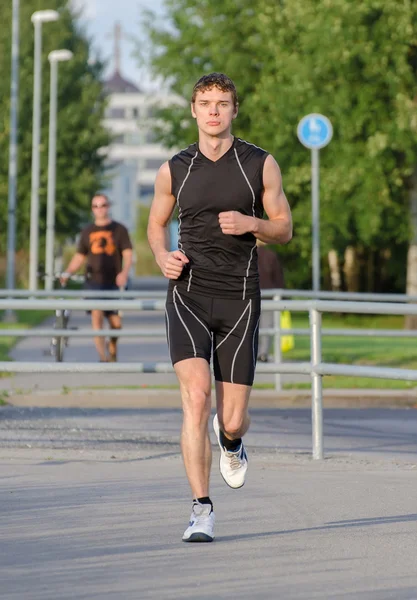 Jovem desportista bonito correndo na rua — Fotografia de Stock