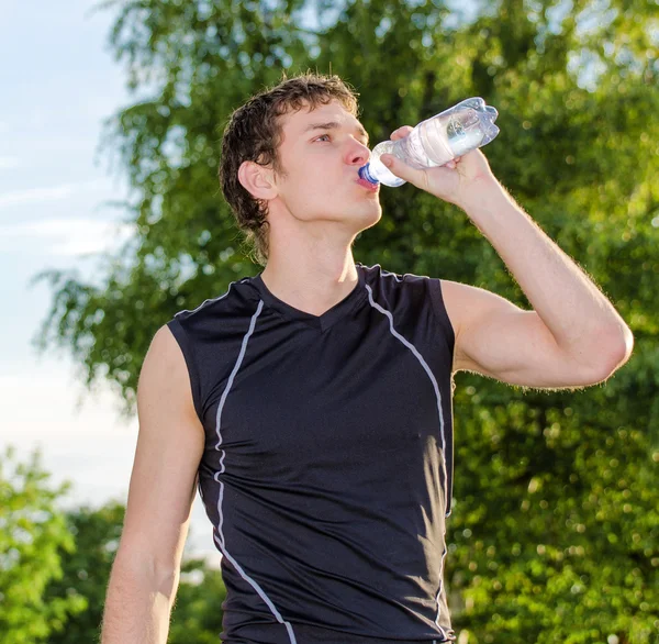 Sportler trinkt nach dem Training Wasser aus der Flasche — Stockfoto