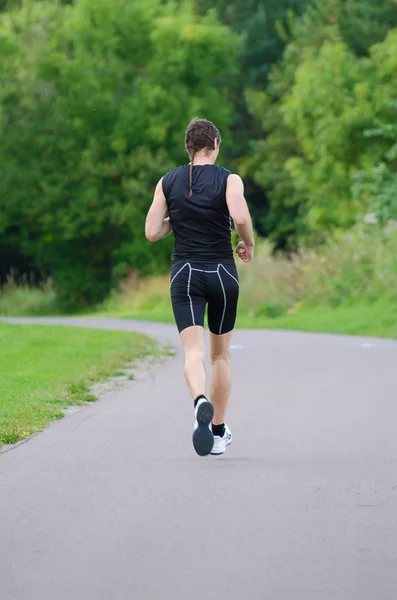 Um desportista a correr no parque. Visão traseira . — Fotografia de Stock