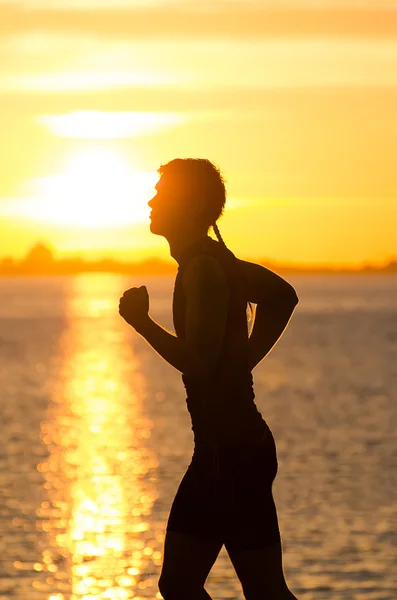 Uomo che corre sulla spiaggia all'alba — Foto Stock