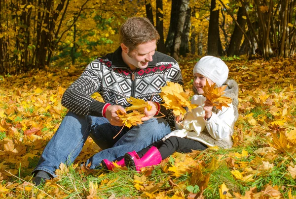 Man and little girl collecting leaves. — Stock Photo, Image