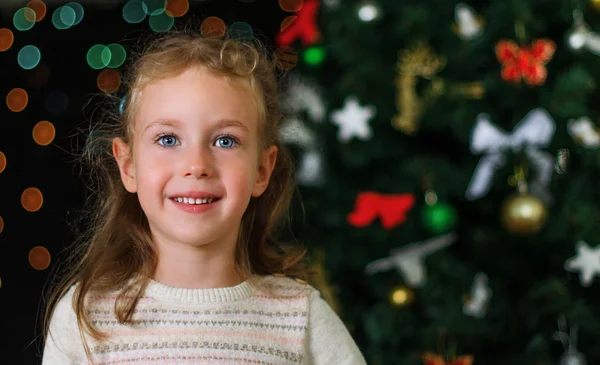 Pequeña niña sonriente sobre las decoraciones de Navidad — Foto de Stock