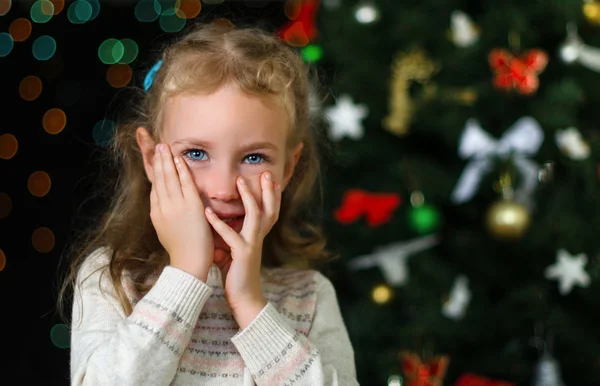 Pequeña chica tímida sobre las decoraciones de Navidad — Foto de Stock