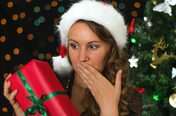 Mulher atraente sendo surpreendida pelo presente de Natal . — Fotografia de Stock