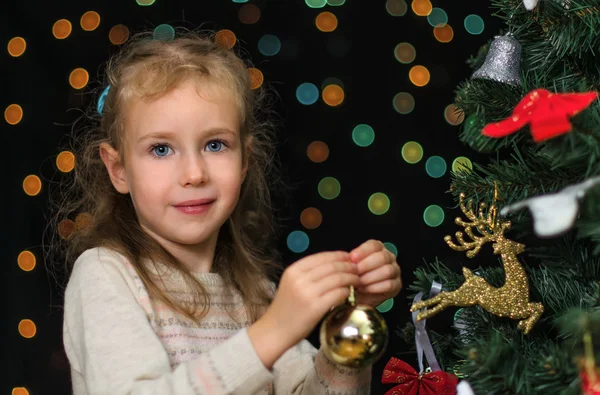 Klein meisje versiert de kerstboom — Stockfoto