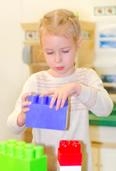 Liten flicka spelar med byggstenar — Stockfoto