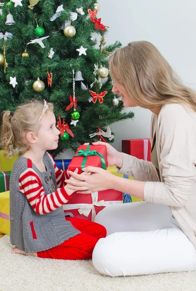 Mère donnant à sa fille cadeau de Noël. — Photo