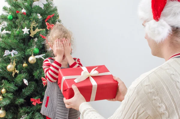 Vader verrassend klein meisje met de gift van Kerstmis — Stockfoto