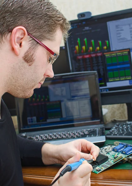 Worker repairing computer equipment with soldering iron — Stock Photo, Image