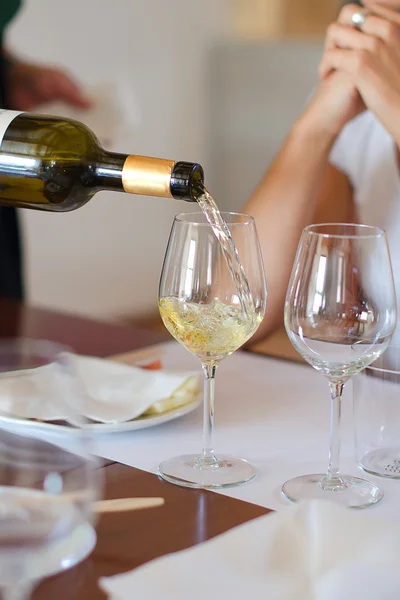 Белое вино наливается в бокал — стоковое фото