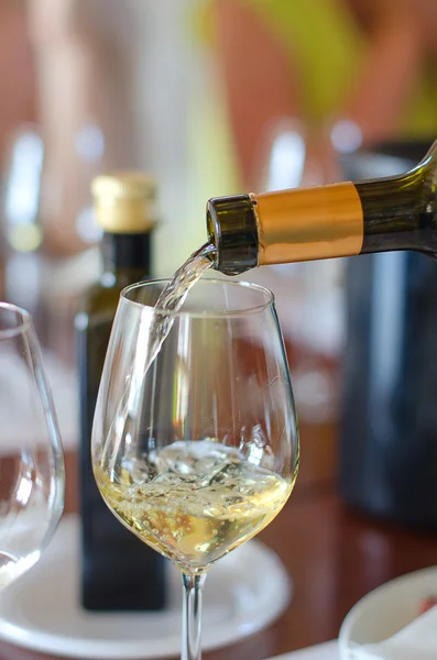 Weißwein wird in Weinglas gegossen — Stockfoto