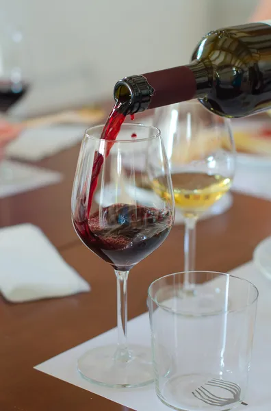 Red wine is pouring into wine glass — Stock Photo, Image