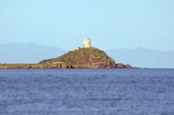 Paisaje oceánico con un antiguo faro en una roca a lo lejos — Foto de Stock