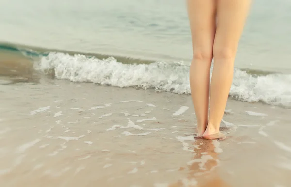 Pary kobiece nogi na brzegu morza — Zdjęcie stockowe