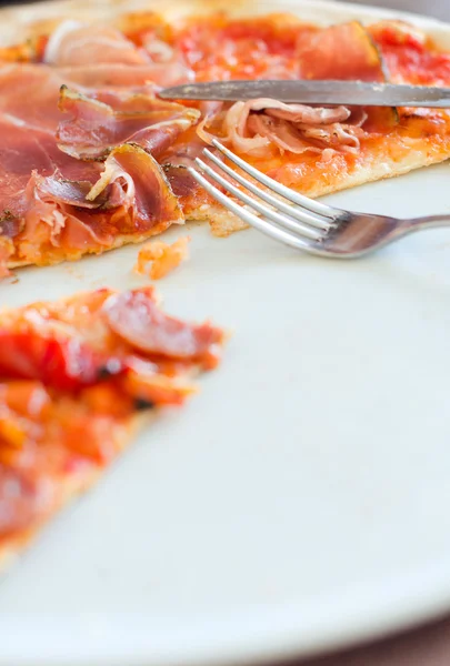 Nahaufnahme einer halben Pizza auf einem Teller — Stockfoto