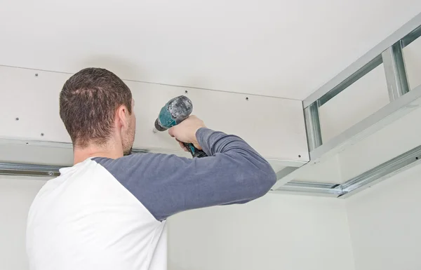 Builder mounting gypsum plasterboard frame on the wall — Stock Photo, Image