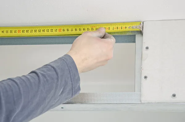 Male hands measuring gypsum plasterboard frame — Stock Photo, Image