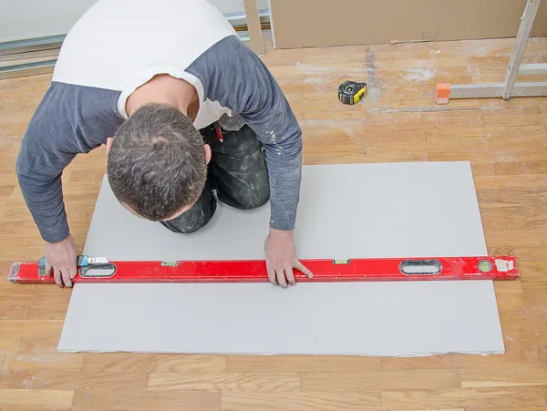 Man measuring and cutting gypsum plasterboard — Stock Photo, Image