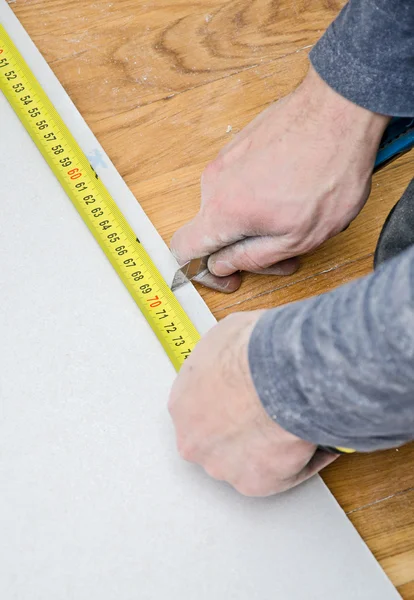 Mannelijke handen meten en snijden gips gipsplaat — Stockfoto