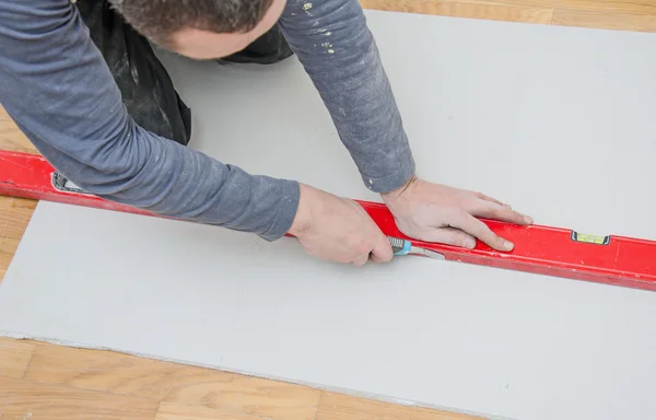 Man measuring and cutting gypsum plasterboard — Stock Photo, Image