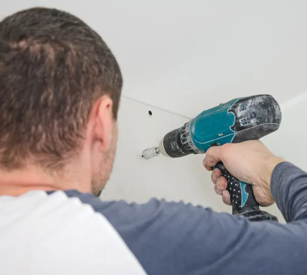 Builder mounting gypsum plasterboard frame on the wall — Stock Photo, Image