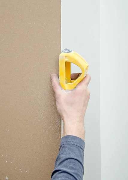 Mannenhand slijpen van gips voor vloeiend oppervlak — Stockfoto