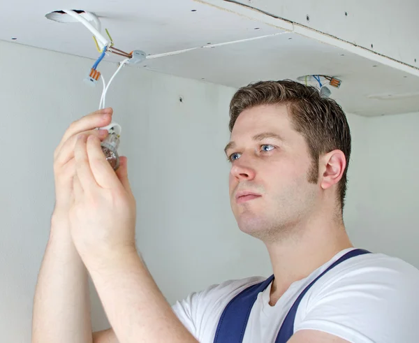 Elettricista certificato che installa presa per lampadina — Foto Stock