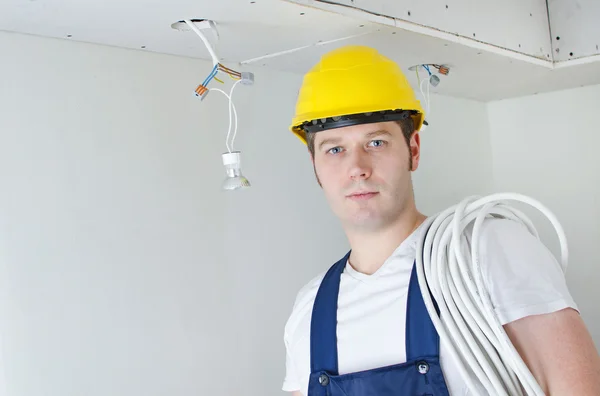 Travailleur électricien certifié en casque jaune — Photo