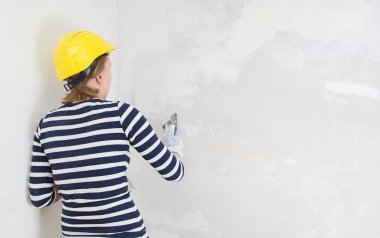 kadın sıvacı, duvar spackling yapıştır ile onarır. alan metni.