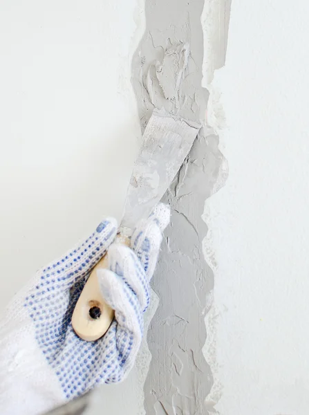 Female hand repairs wall with spackling paste — Stock Photo, Image