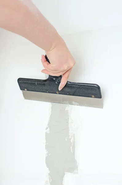 Mão feminina reparos parede com pasta spackling — Fotografia de Stock