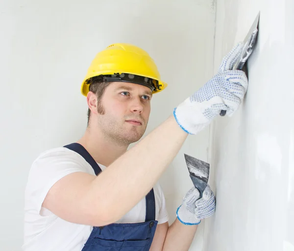 Male builder repairs wall with spackling paste — Stock Photo, Image