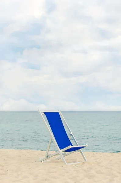 Chaise longue solitaire à ossature métallique sur la plage. Espace pour le texte . — Photo