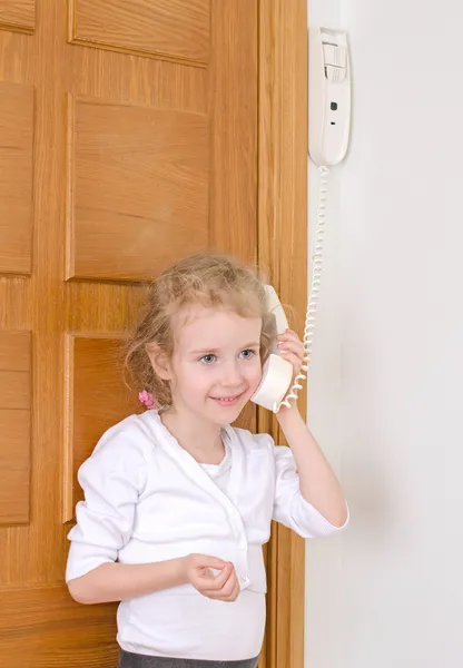 Lilla flickan talar på porttelefonen hemma. — Stockfoto