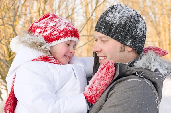 Glücklicher Vater und Tochter, die Spaß im Winterpark haben. — Stockfoto