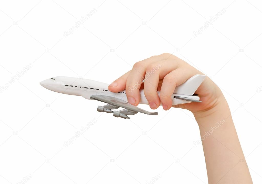 Child hand holding model airplane. Isolated on white.