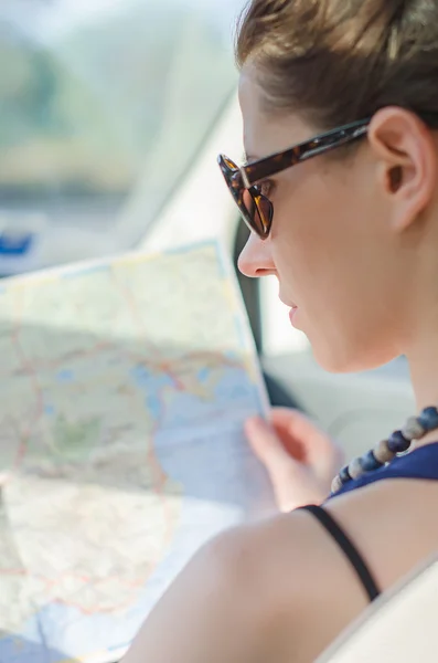 Turista feminino olhando para o mapa no carro . — Fotografia de Stock