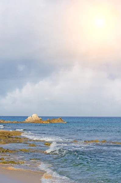Sunny beach with rocks and blue sea. — Stock Photo, Image