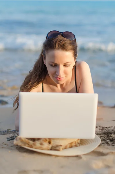 Kadın plajda çalışan dizüstü bilgisayar ile. — Stok fotoğraf